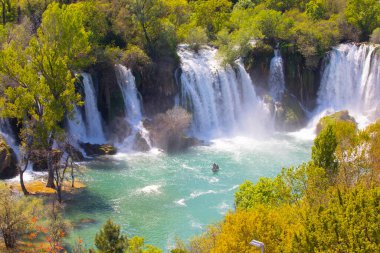 Güney Bosna-Hersek 'te Kravica şelalelerinin altında kürek çeken küçük bir tekne.