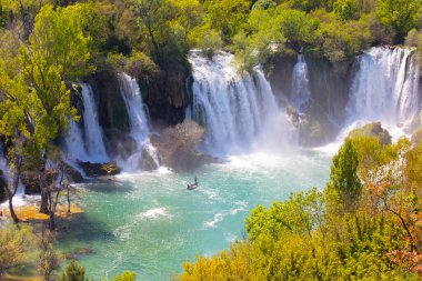 Güney Bosna-Hersek 'te Kravica şelalelerinin altında kürek çeken küçük bir tekne.