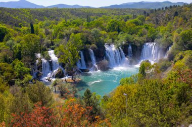 Güney Bosna-Hersek 'te Kravica şelalelerinin altında kürek çeken küçük bir tekne.
