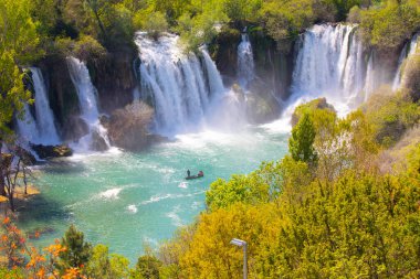 Güney Bosna-Hersek 'te Kravica şelalelerinin altında kürek çeken küçük bir tekne.