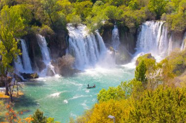 Güney Bosna-Hersek 'te Kravica şelalelerinin altında kürek çeken küçük bir tekne.