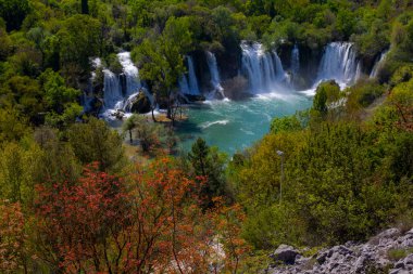 Güney Bosna-Hersek 'te Kravica şelalelerinin altında kürek çeken küçük bir tekne.