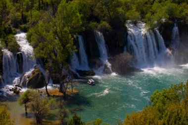 Güney Bosna-Hersek 'te Kravica şelalelerinin altında kürek çeken küçük bir tekne.