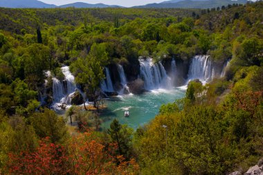 Güney Bosna-Hersek 'te Kravica şelalelerinin altında kürek çeken küçük bir tekne.