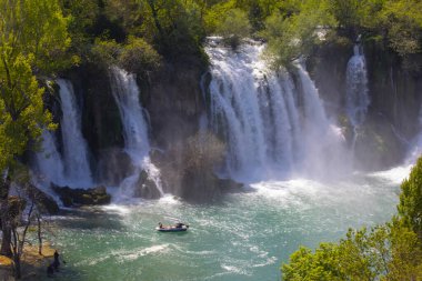 Güney Bosna-Hersek 'te Kravica şelalelerinin altında kürek çeken küçük bir tekne.