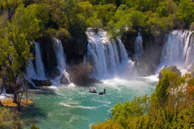 Güney Bosna-Hersek 'te Kravica şelalelerinin altında kürek çeken küçük bir tekne.