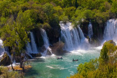 Güney Bosna-Hersek 'te Kravica şelalelerinin altında kürek çeken küçük bir tekne.