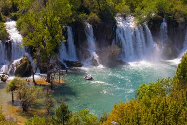 Güney Bosna-Hersek 'te Kravica şelalelerinin altında kürek çeken küçük bir tekne.