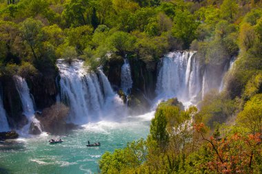Güney Bosna-Hersek 'te Kravica şelalelerinin altında kürek çeken küçük bir tekne.