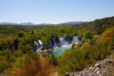 Güney Bosna-Hersek 'te Kravica şelalelerinin altında kürek çeken küçük bir tekne.