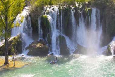 Güney Bosna-Hersek 'te Kravica şelalelerinin altında kürek çeken küçük bir tekne.