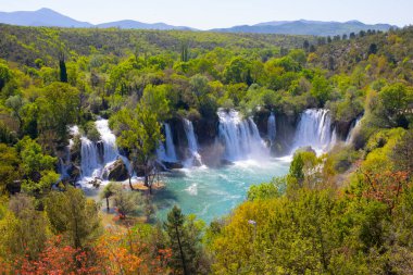 Güney Bosna-Hersek 'te Kravica şelalelerinin altında kürek çeken küçük bir tekne.
