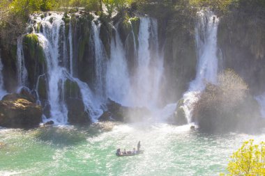 Güney Bosna-Hersek 'te Kravica şelalelerinin altında kürek çeken küçük bir tekne.
