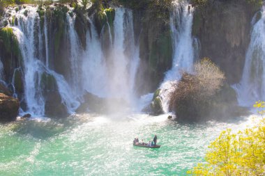 Güney Bosna-Hersek 'te Kravica şelalelerinin altında kürek çeken küçük bir tekne.