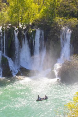 Güney Bosna-Hersek 'te Kravica şelalelerinin altında kürek çeken küçük bir tekne.
