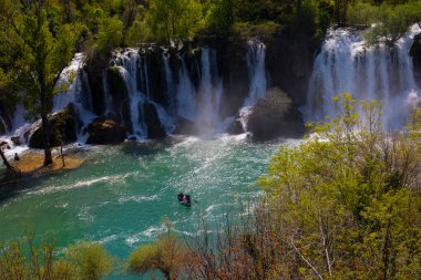 Güney Bosna-Hersek 'te Kravica şelalelerinin altında kürek çeken küçük bir tekne.