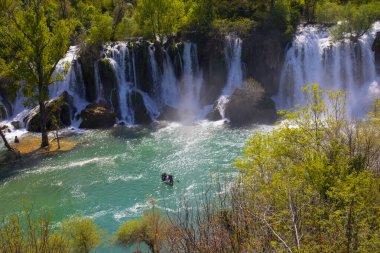 Güney Bosna-Hersek 'te Kravica şelalelerinin altında kürek çeken küçük bir tekne.