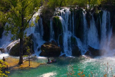 Güney Bosna-Hersek 'te Kravica şelalelerinin altında kürek çeken küçük bir tekne.