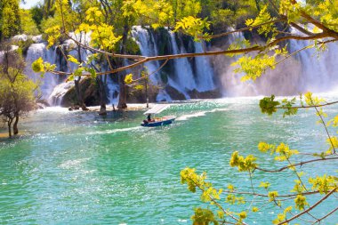Güney Bosna-Hersek 'te Kravica şelalelerinin altında kürek çeken küçük bir tekne.
