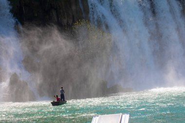 Güney Bosna-Hersek 'te Kravica şelalelerinin altında kürek çeken küçük bir tekne.
