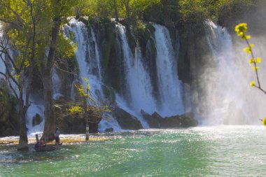 Güney Bosna-Hersek 'te Kravica şelalelerinin altında kürek çeken küçük bir tekne.