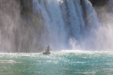 Güney Bosna-Hersek 'te Kravica şelalelerinin altında kürek çeken küçük bir tekne.