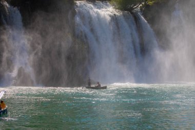 Güney Bosna-Hersek 'te Kravica şelalelerinin altında kürek çeken küçük bir tekne.