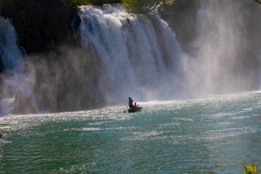 Güney Bosna-Hersek 'te Kravica şelalelerinin altında kürek çeken küçük bir tekne.