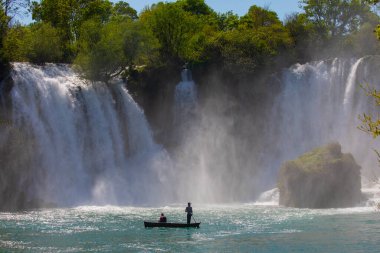 Güney Bosna-Hersek 'te Kravica şelalelerinin altında kürek çeken küçük bir tekne.