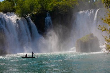 Güney Bosna-Hersek 'te Kravica şelalelerinin altında kürek çeken küçük bir tekne.