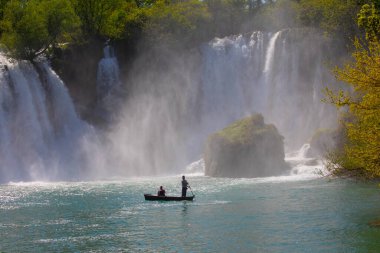 Güney Bosna-Hersek 'te Kravica şelalelerinin altında kürek çeken küçük bir tekne.