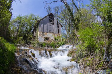 Old mill in the Una National Park. The Una River flows under the mill. Summer landscape in the National Park.