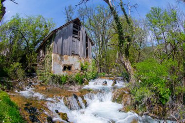 Old mill in the Una National Park. The Una River flows under the mill. Summer landscape in the National Park.