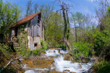 Old mill in the Una National Park. The Una River flows under the mill. Summer landscape in the National Park.