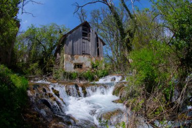 Old mill in the Una National Park. The Una River flows under the mill. Summer landscape in the National Park.