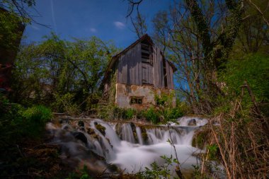 Old mill in the Una National Park. The Una River flows under the mill. Summer landscape in the National Park.