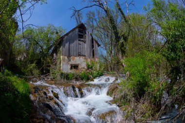 Old mill in the Una National Park. The Una River flows under the mill. Summer landscape in the National Park.
