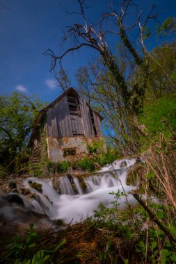 Old mill in the Una National Park. The Una River flows under the mill. Summer landscape in the National Park.