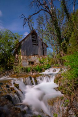 Old mill in the Una National Park. The Una River flows under the mill. Summer landscape in the National Park.