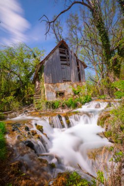 Old mill in the Una National Park. The Una River flows under the mill. Summer landscape in the National Park.