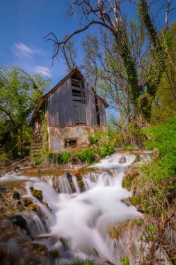 Old mill in the Una National Park. The Una River flows under the mill. Summer landscape in the National Park.