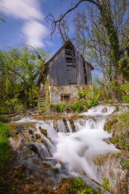 Old mill in the Una National Park. The Una River flows under the mill. Summer landscape in the National Park.