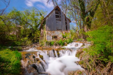 Old mill in the Una National Park. The Una River flows under the mill. Summer landscape in the National Park.