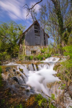 Old mill in the Una National Park. The Una River flows under the mill. Summer landscape in the National Park.