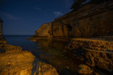 Gece sahilindeki kayalıklarda uzun pozlar.