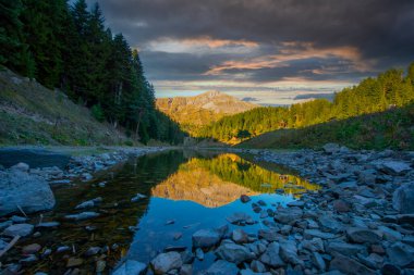 Avat balık gölünün sakin suyu ve arkadaki dağ manzarası, harika doğa manzarası..