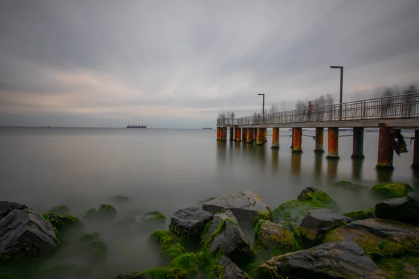 The aesthetic pier by the sea was photographed with the long exposure technique.