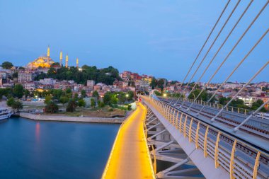 İstanbul 'da metro, Haliç yer istasyonu, Fatih ilçesi ve arkada Süleyman camisi, köprüde yürüyen insanlar, gün batımı