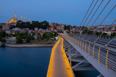 İstanbul 'da metro, Haliç yer istasyonu, Fatih ilçesi ve arkada Süleyman camisi, köprüde yürüyen insanlar, gün batımı