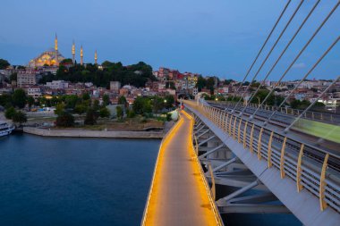 İstanbul 'da metro, Haliç yer istasyonu, Fatih ilçesi ve arkada Süleyman camisi, köprüde yürüyen insanlar, gün batımı